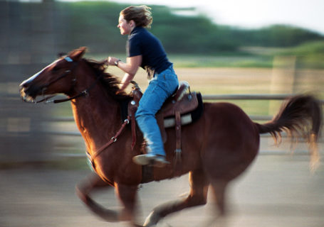 Barrel rider races her horse in practice, Indian Head Saskatchewan Canada - Photo by David Innes