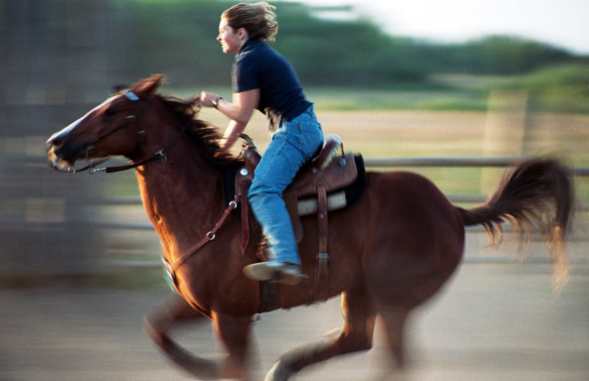 Barrel rider races her horse in practice, Indian Head Saskatchewan Canada - Photo by David Innes